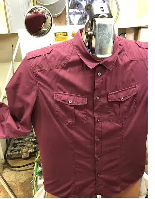 Freshly pressed dress shirt on a hanger at Frankie's Cleaners